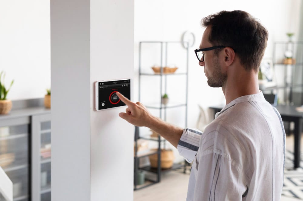 Mann programmiert ein Sicherheitssystem im Einfamilienhaus