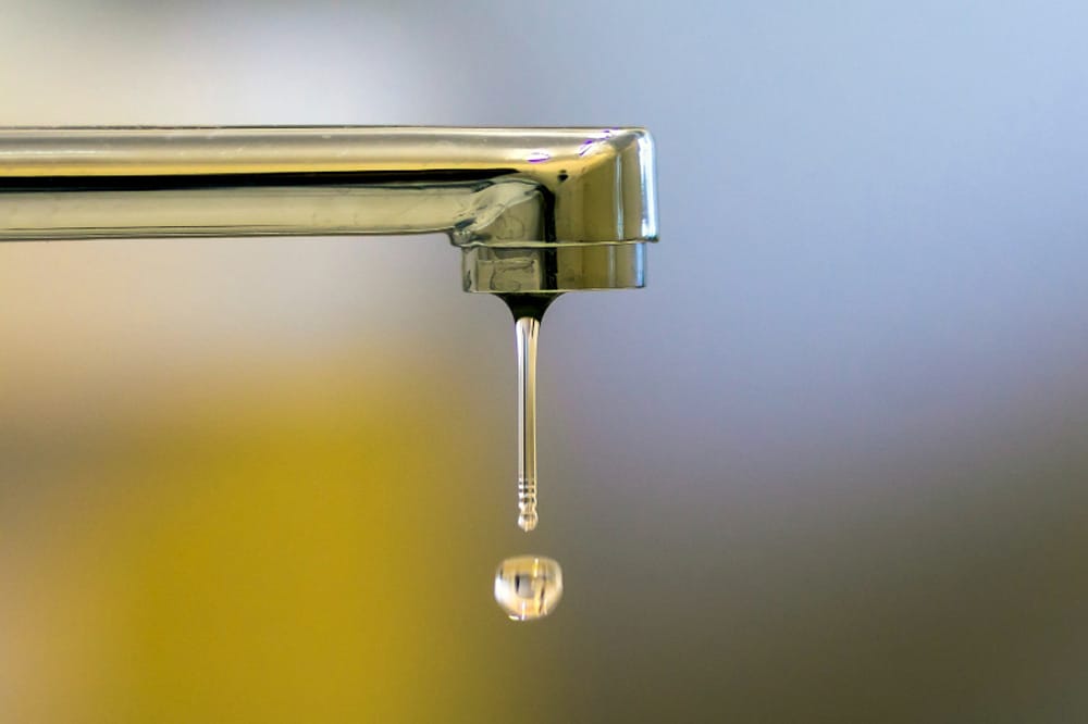 Zoom auf einen tropfenden Wasserhahn
